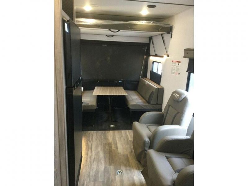 Forest River RV XLR Micro Boost 301XLRE toy hauler fifth wheel interior garage view with a dinette and recliner